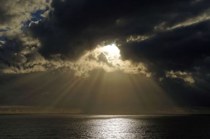 Sun_breaking_through_clouds_over_ocean_bigwavephoto